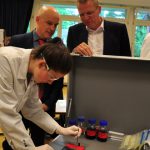 Schulleiter Dr. Christian Gefert und der Geschäftsführer Dirk Greshake von AstraZeneca freuen sich über das mobile Labor