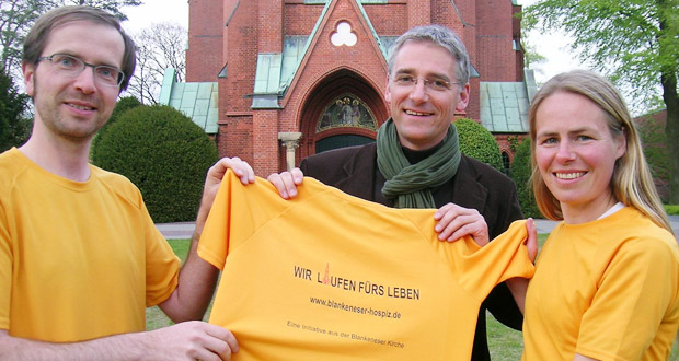 Pastor Thomas Warnke (Mitte) bekommt das Heldenlauf-Shirt von Christine Dörscher und Hermann Bach