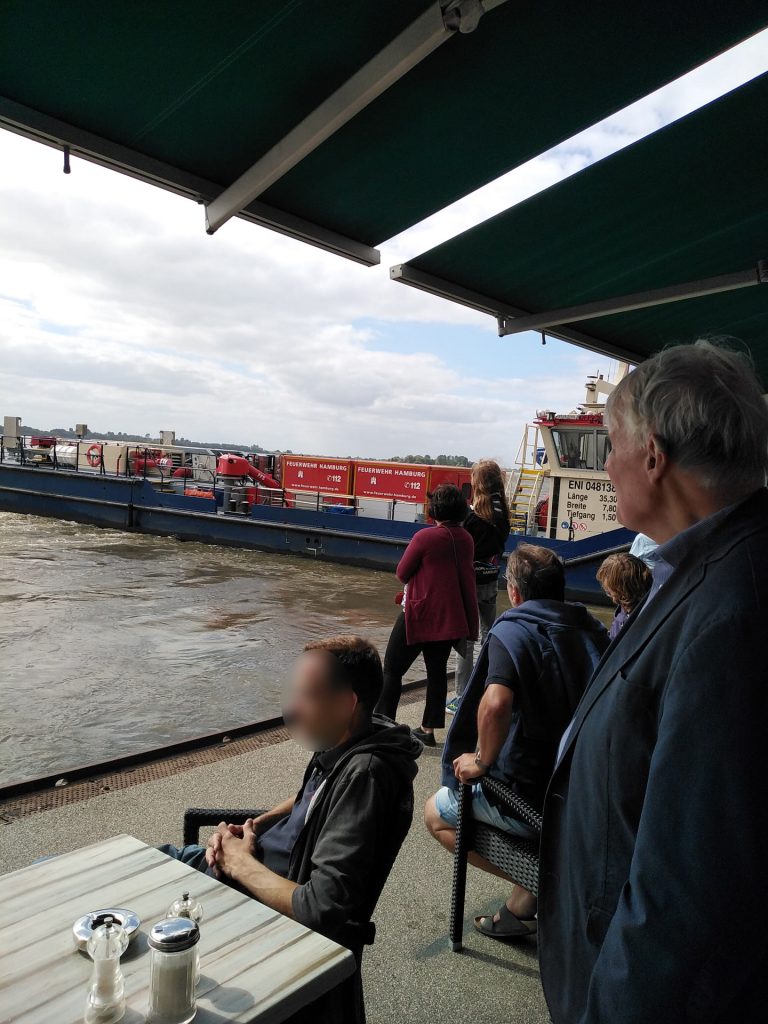 Einsatz eines Löschboots, um die Elbe im Gefahrenbereich zu „beruhigen“. Der Boot schirmt den Bereich von der Strömung ab, in dem es längs zur Fließrichtung dreht. 