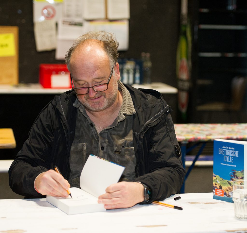 Autor Jörg Bong, alias Jean-Luc Bannalec, Schöpfer des Commissaire Dupin. Er signiert ein Buch beim Krimifestival. // Foto: Stefanie Kapra
