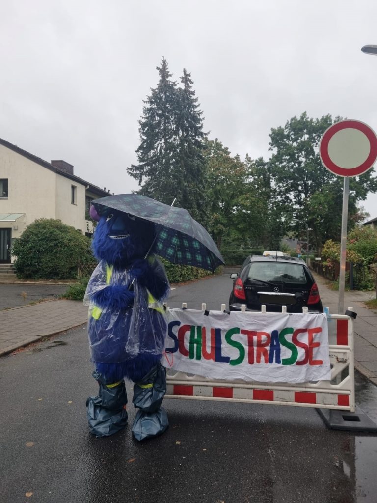 Ein Verkehrsmonster scheut Regen nicht. Tapfer steht es am Eingang der provisorischen Schulstraße. // Foto: Elternrat Schule Wesperloh.