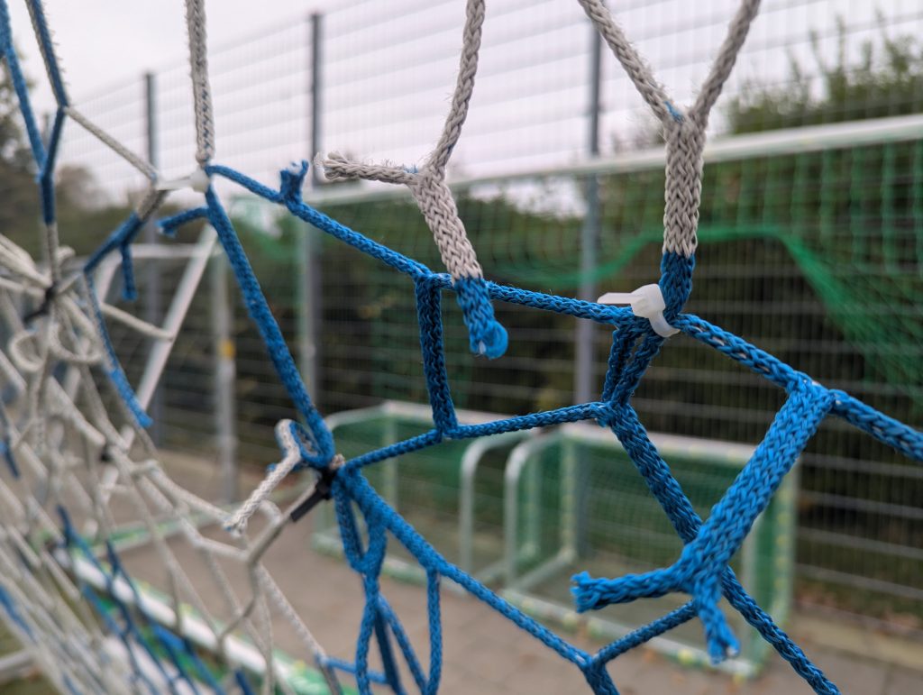 Der Platzwart des Vereins flickte einige Netze notdürftig mit Kabelbindern, damit das anstehende Spiel stattfinden konnte.