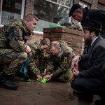 Während des Putzens berichten Militärrabbiner Shmuel Havlin (re. knieend) und Dr. Uwe Janzen, 2. Vorsitzender der jüdischen Gemeinde, den Soldatinnen und Soldaten vom jüdischen Leben in Hamburg. // Foto: Bundeswehr/Pieter-Pan Rupprecht - Stolpersteine