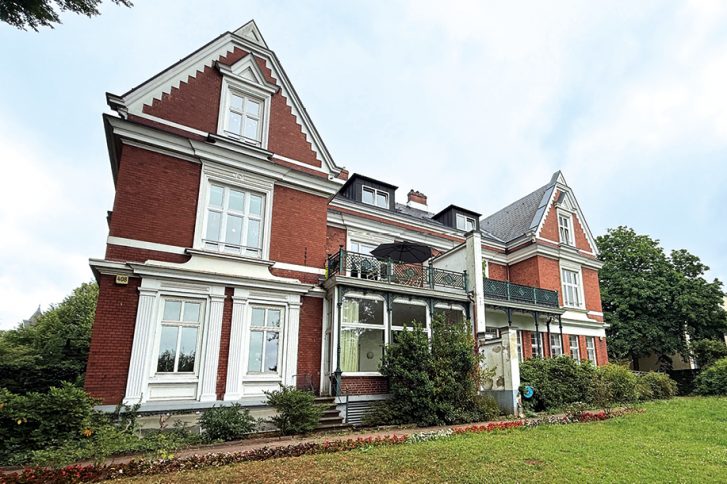 Das Gebäude an der Elbchaussee 408 war früher ein Doppelgemeindehaus, was sich außen noch heute an den äußeren Querhäusern und einer Trennung zeigt.