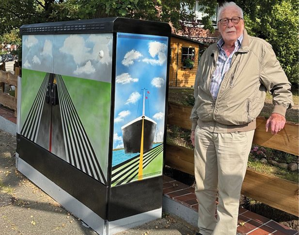 Künstler Heinz „Heiner“ Eimert vor seiner Leinwand – dem Stromkasten an der Ecke Sülldorfer Heideweg / Forsteck. - Künstler