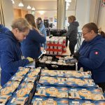 Viele Hände verteilen die Spenden in Tüten.