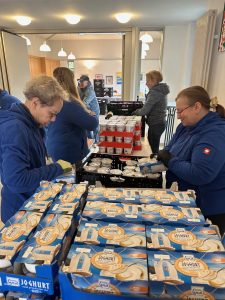 Viele Hände verteilen die Spenden in Tüten.